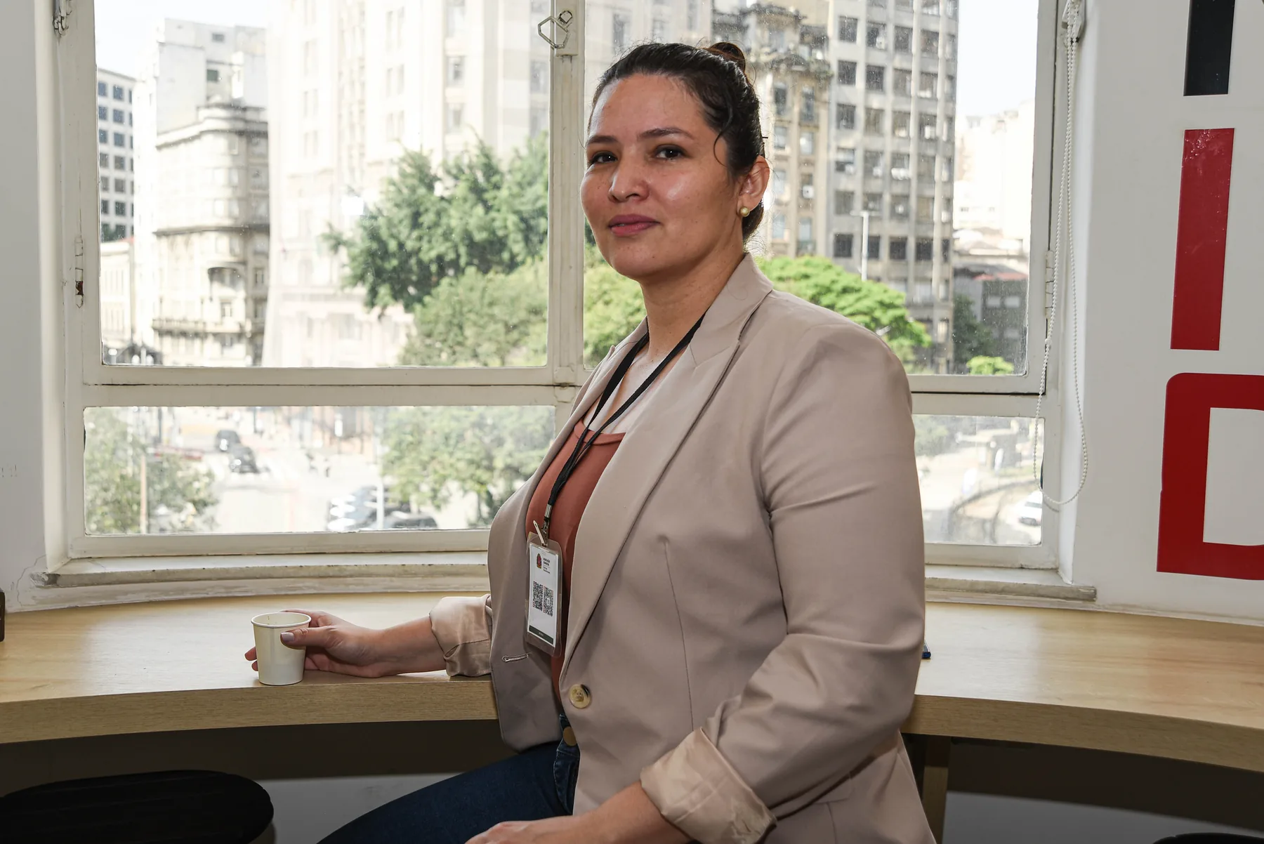 Dra. Oriana sentada junto a uma janela durante um evento