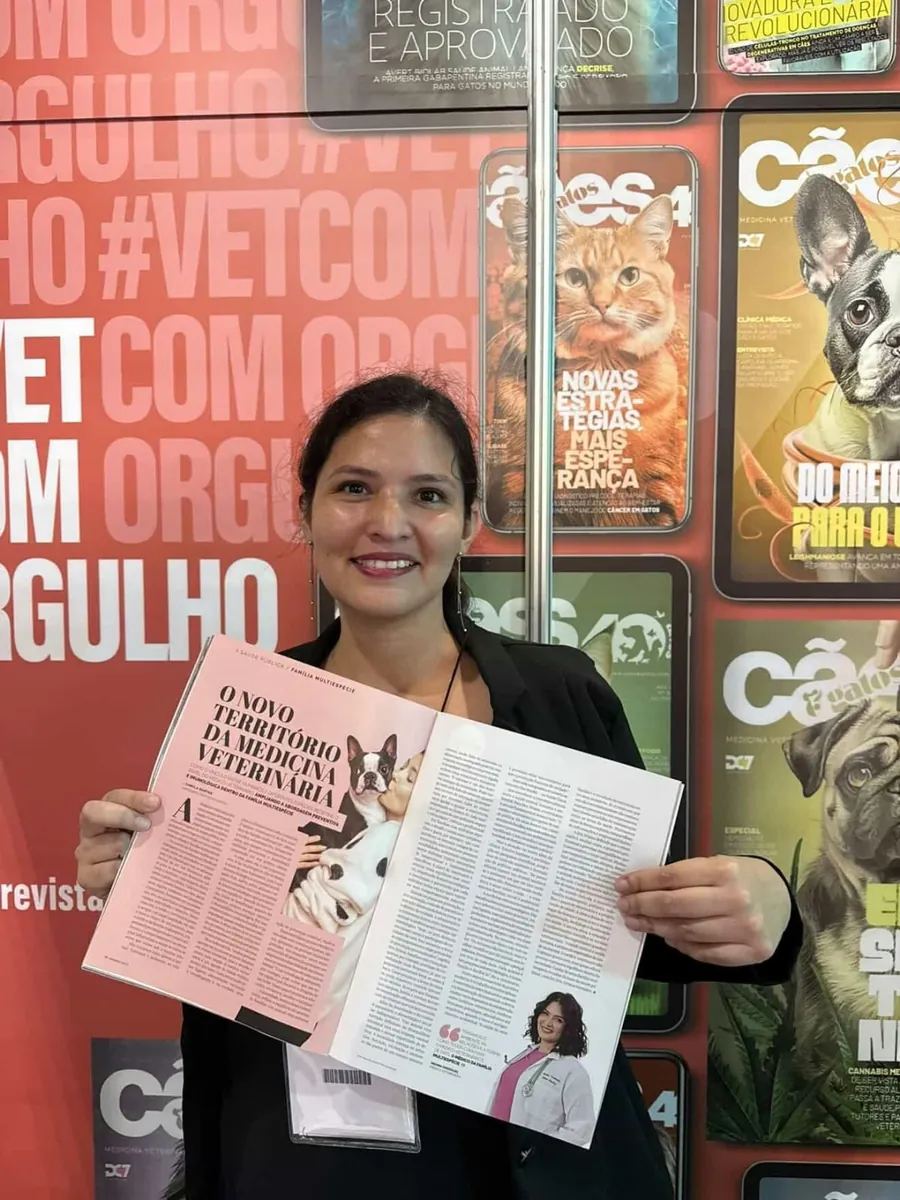 Dra. Oriana sorrindo e segurando a revista Cães e Gatos aberta na reportagem O novo território da Medicina Veterinária